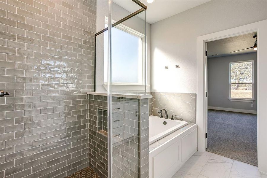 Bathroom with a bath, a walk in shower, and light marble finish flooring