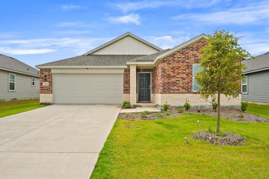 View of front of property featuring a garage and a front yard