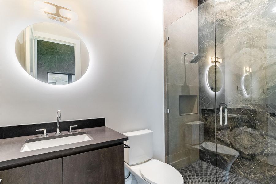 Bathroom featuring toilet, a stall shower, and vanity Bathroom featuring toilet, a stall shower, and vanity