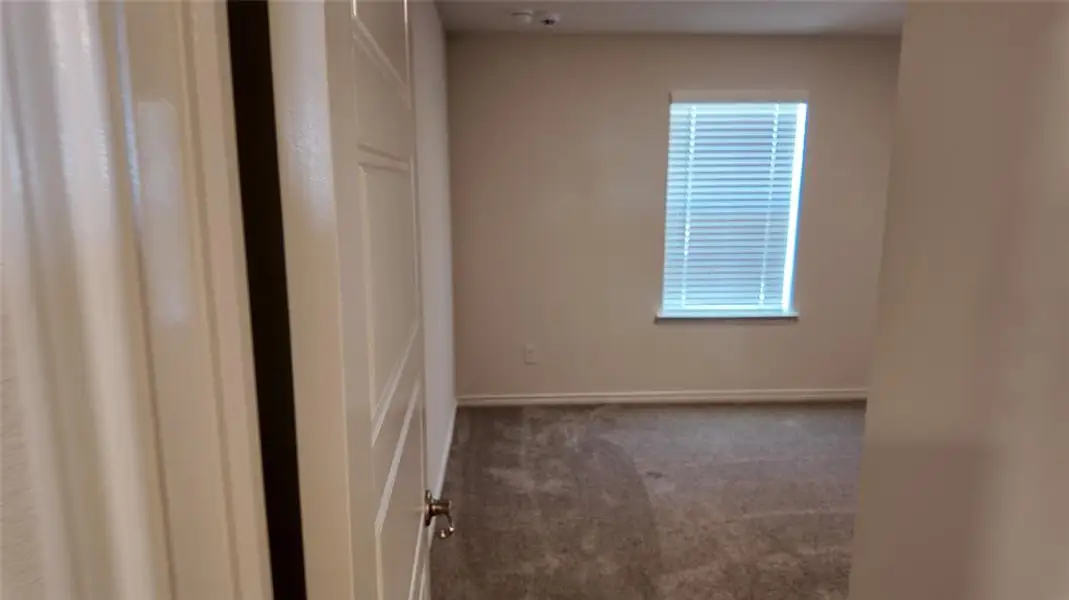 Carpeted empty room with baseboards