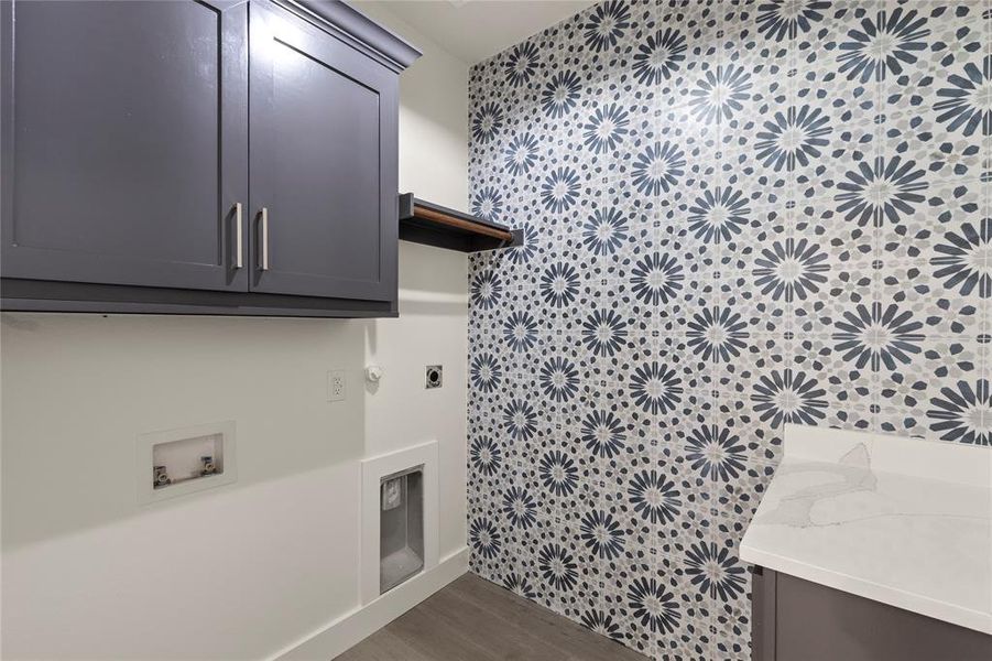 Washroom featuring cabinet space, hookup for an electric dryer, hookup for a washing machine, dark wood-type flooring, and hookup for a gas dryer