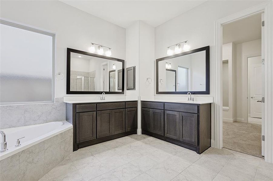 Bathroom featuring vanity and shower with separate bathtub