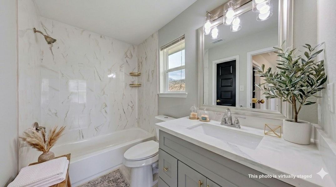 Elegant neutral tones and stylish three-light fixtures create a bright, spa-like atmosphere in your perfectly curated private primary bath.
