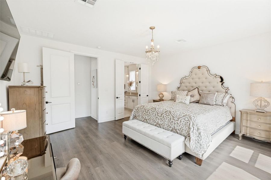 Smooth wood floors and crisp white walls define this airy primary suite.
