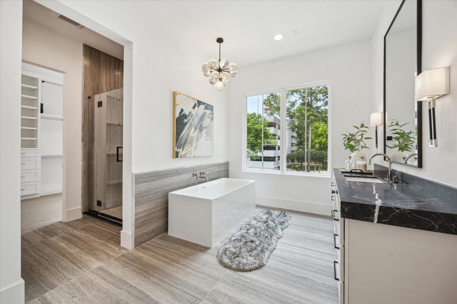 Primary bathroom features a Sterling Unwind freestanding rectangle soaking tub with Kallista One wall-mounted faucet, framed glass shower with Laticrete shower system, and two separate vanity areas.