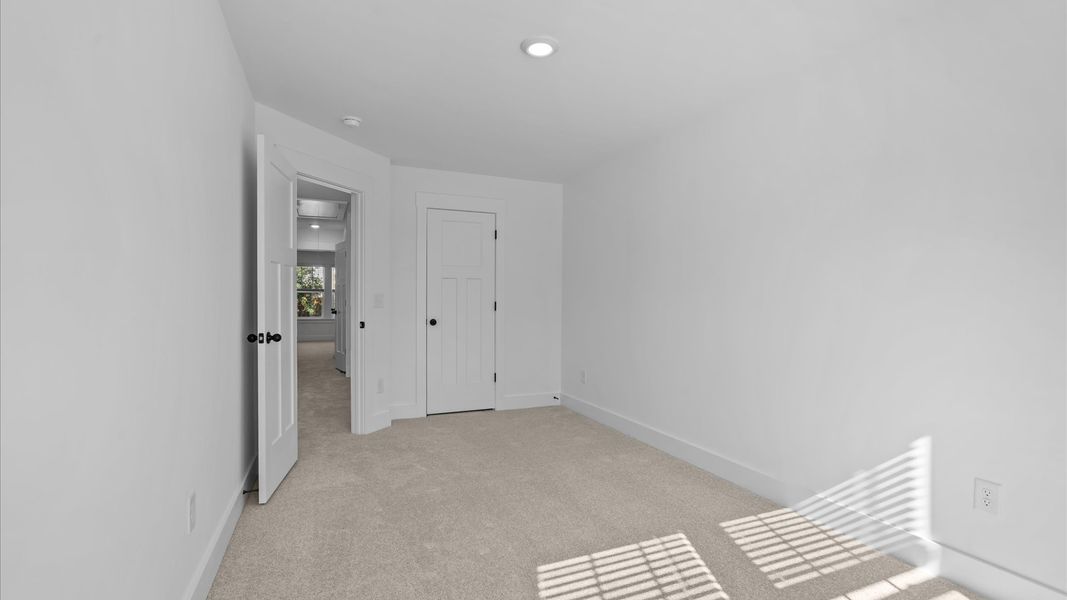 First-class secondary bedroom with comfortable carpeted flooring and generous closet space