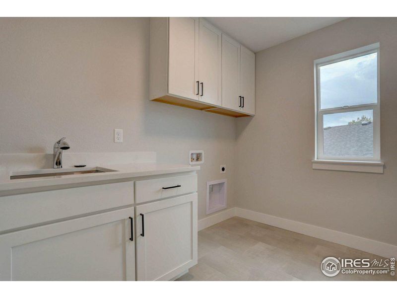 Upper level laundry room with a sink and a window!