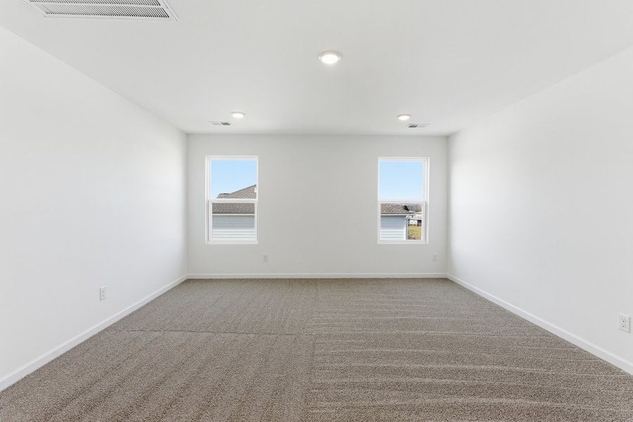 A room with a carpet and windows.