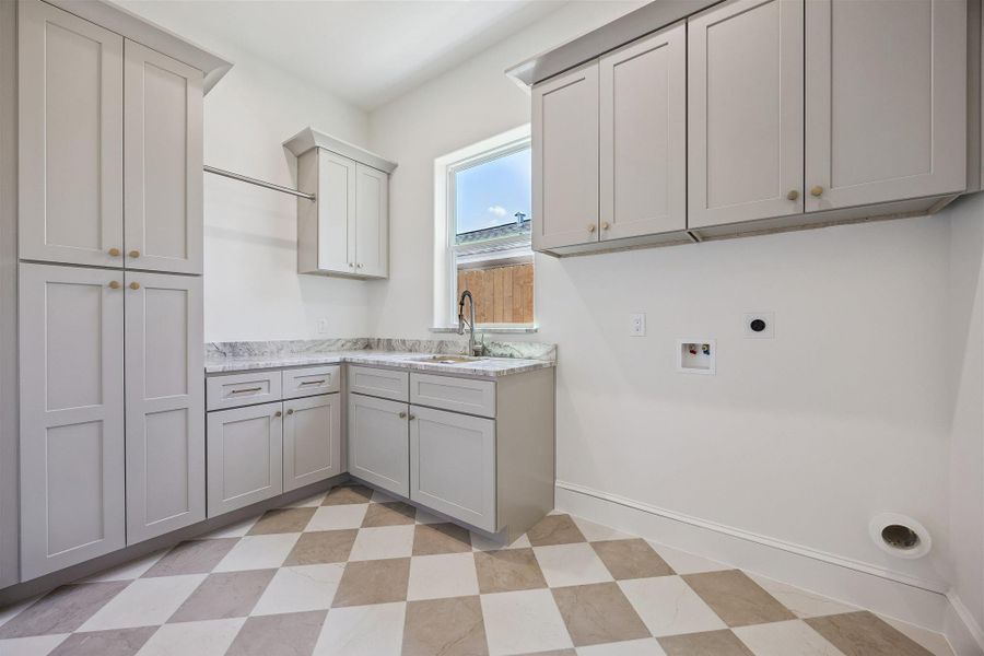 Laundry room with sink and abundant storage on first floor