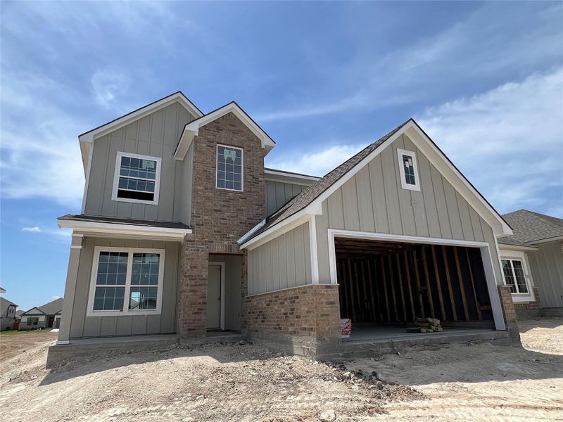 View of front facade with board and batten siding, brick siding, and a shingled roof View of front facade with board and batten siding, brick siding, and a shingled roof