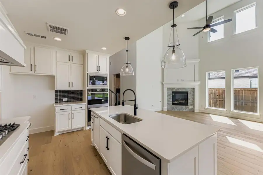 Kitchen featuring white cabinetry, stainless steel appliances, healthy amount of natural light, light wood finished floors, and recessed lighting
