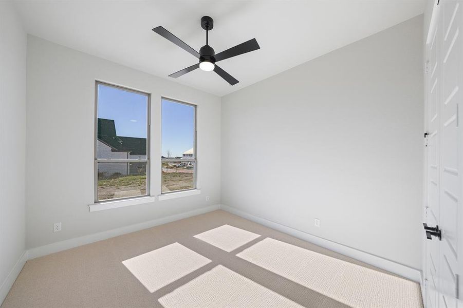 Carpeted spare room featuring baseboards and a ceiling fan Carpeted spare room featuring baseboards and a ceiling fan