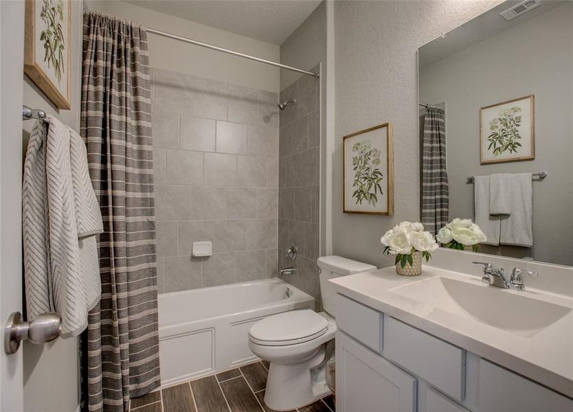 Bathroom with vanity, shower / bath combo with shower curtain, and wood tiled floors Bathroom with vanity, shower / bath combo with shower curtain, and wood tiled floors