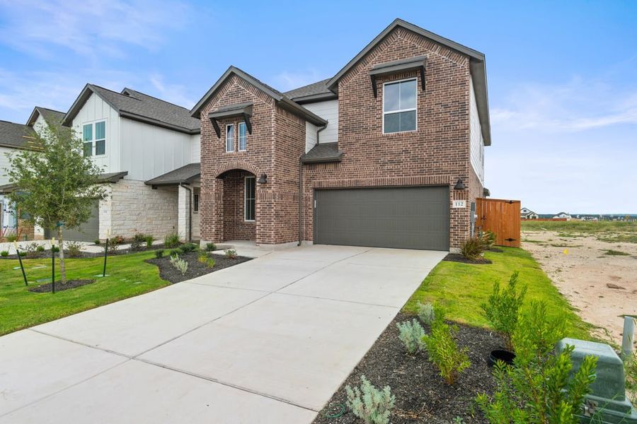 Front exterior of a new home in Terrace Collection at Lariat, Liberty Hill, TX, highlighting curb appeal (Image 2). Front exterior of a new home in Terrace Collection at Lariat, Liberty Hill, TX, highlighting curb appeal (Image 2).