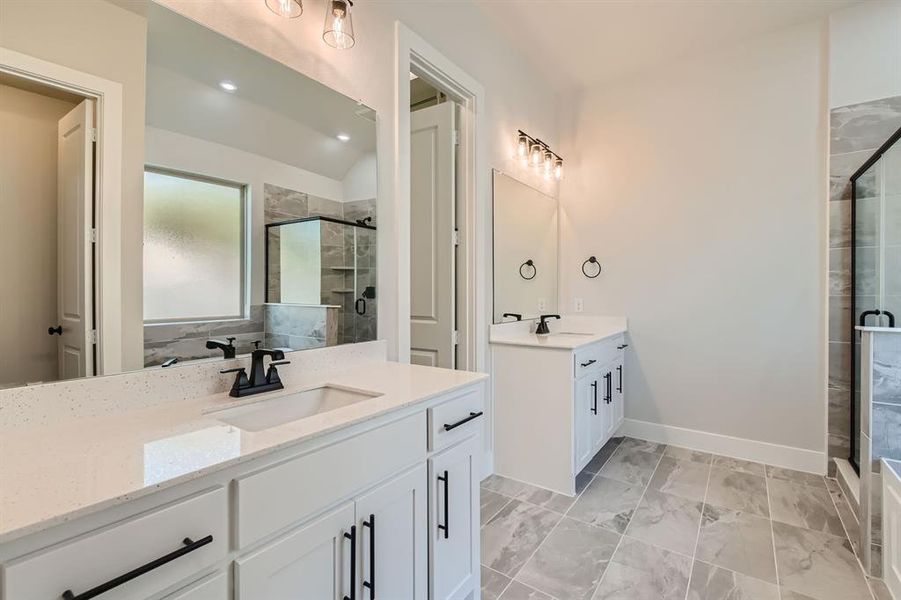 Bathroom featuring vanity and a shower with door