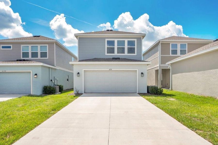 Front exterior of a new home in Wellness Ridge, Clermont, FL, highlighting curb appeal (Image 22).