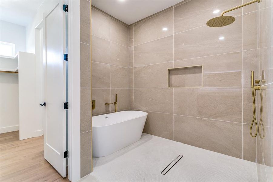 Bathroom featuring a freestanding tub, tiled shower, and wood finished floors Bathroom featuring a freestanding tub, tiled shower, and wood finished floors