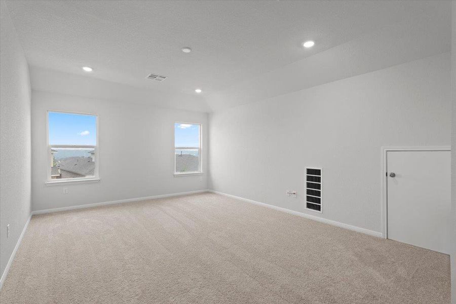 Spacious room featuring neutral carpeting, recessed lighting, and two windows providing natural illumination