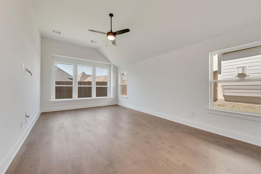 Spare room featuring lofted ceiling, ceiling fan, and light wood finished floors Spare room featuring lofted ceiling, ceiling fan, and light wood finished floors