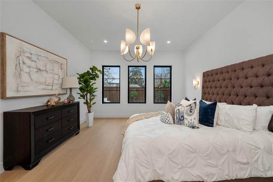 Bedroom featuring light wood-style floors and hanging lights Bedroom featuring light wood-style floors and hanging lights