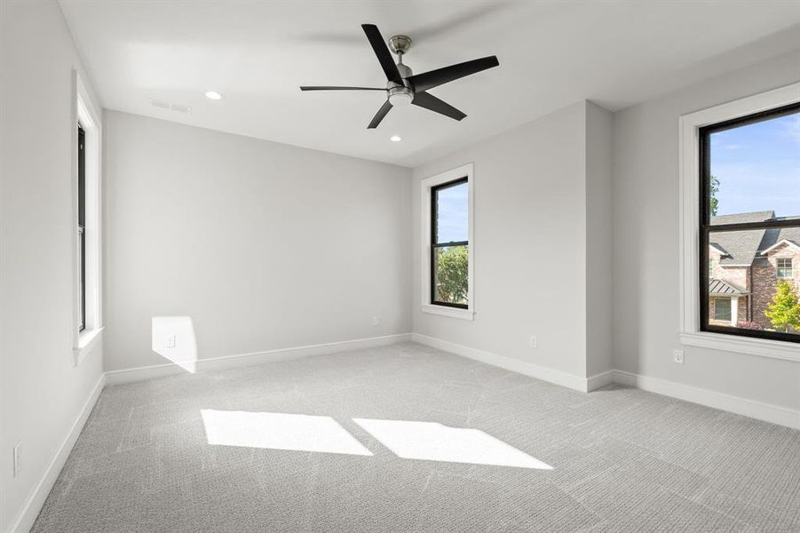 Carpeted spare room with a ceiling fan and recessed lighting Carpeted spare room with a ceiling fan and recessed lighting