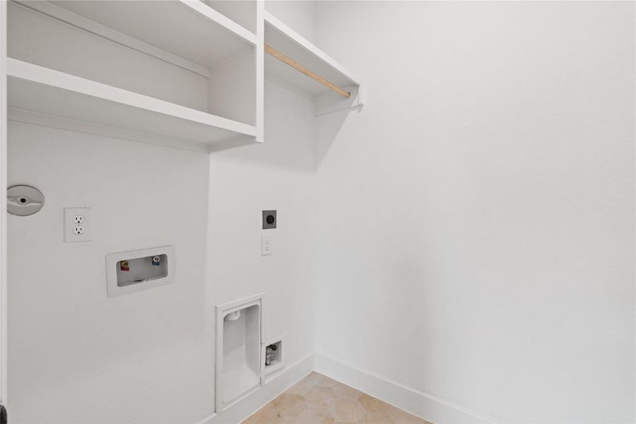 Dedicated laundry area with built-in shelving and washer/dryer connections.
