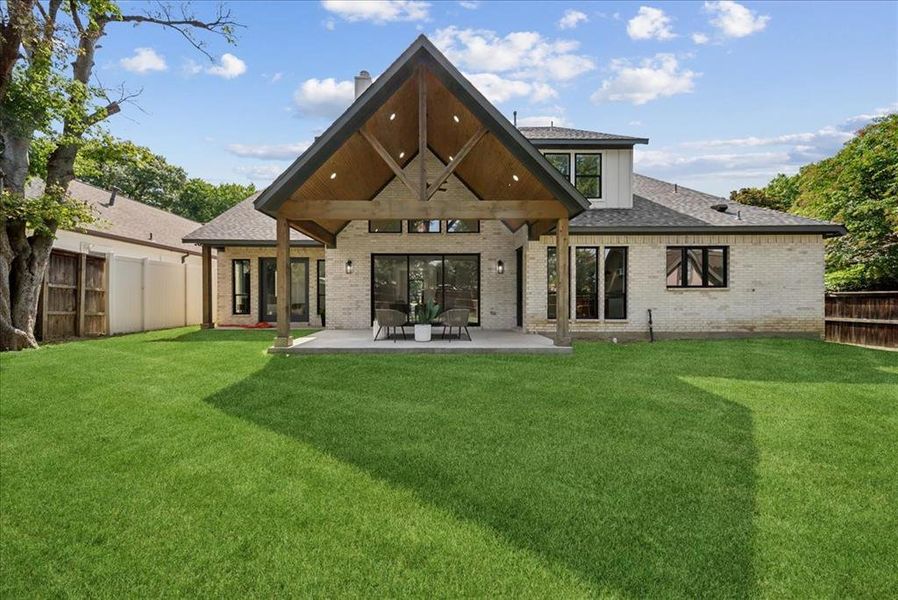 Rear view of house with a patio and a yard