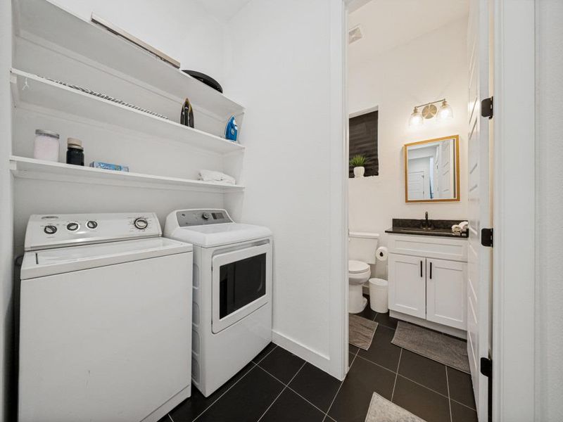 Functional laundry facilities blend seamlessly with a conveniently adjacent powder room, creating an efficient household utility space. Functional laundry facilities blend seamlessly with a conveniently adjacent powder room, creating an efficient household utility space.