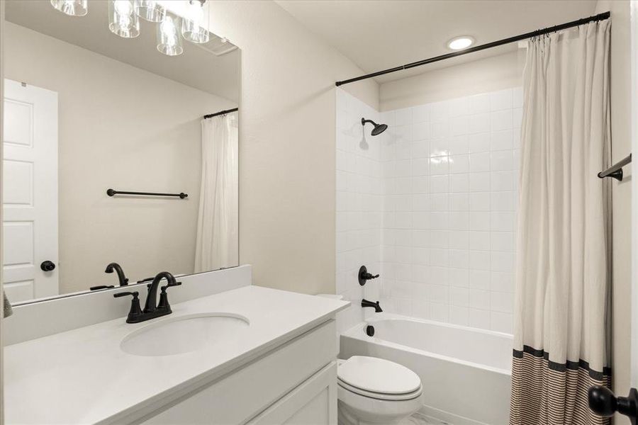 Bathroom featuring shower / bath combination with curtain and vanity
