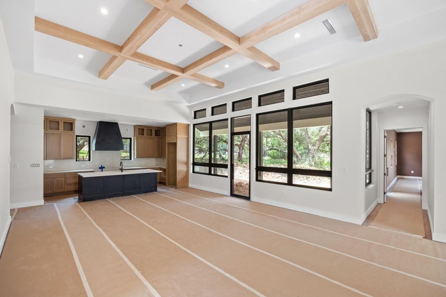 Spacious open-concept interior featuring a coffered ceiling with wood-finish beams