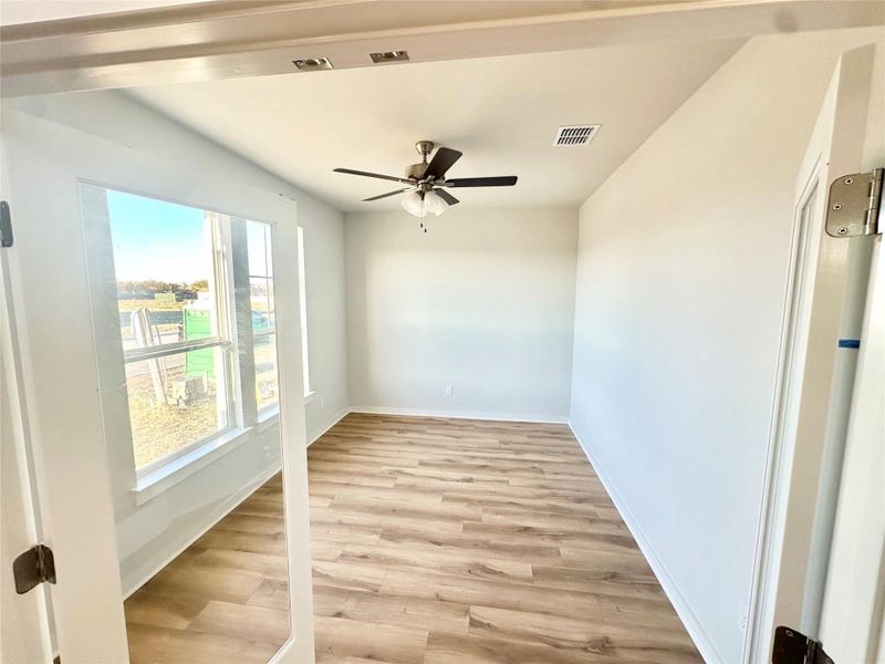 Spare room with light wood finished floors and ceiling fan