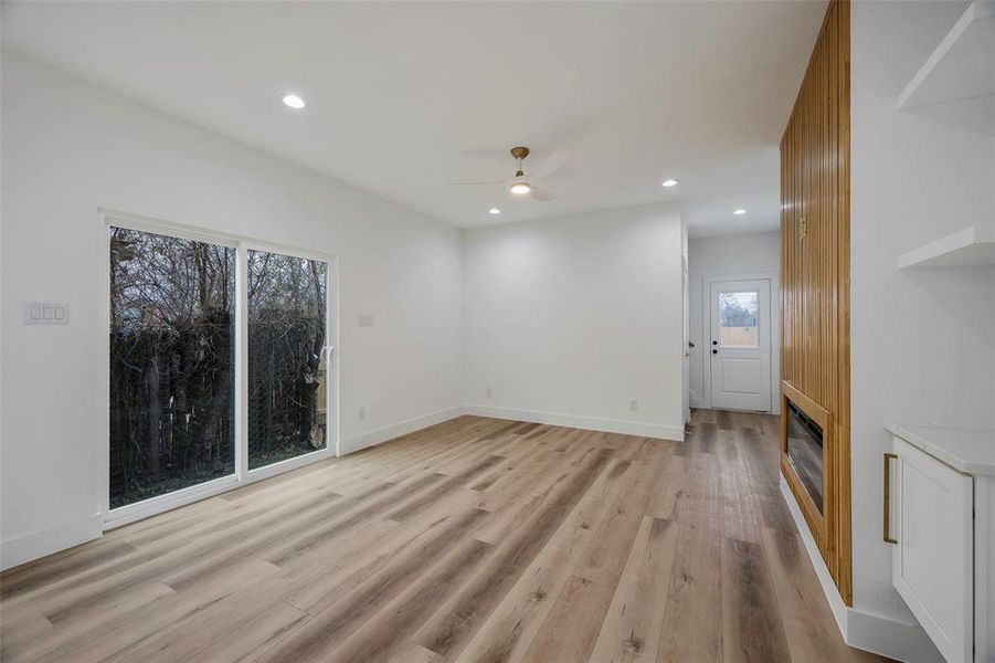 Unfurnished living room featuring ceiling fan and light wood-type flooring