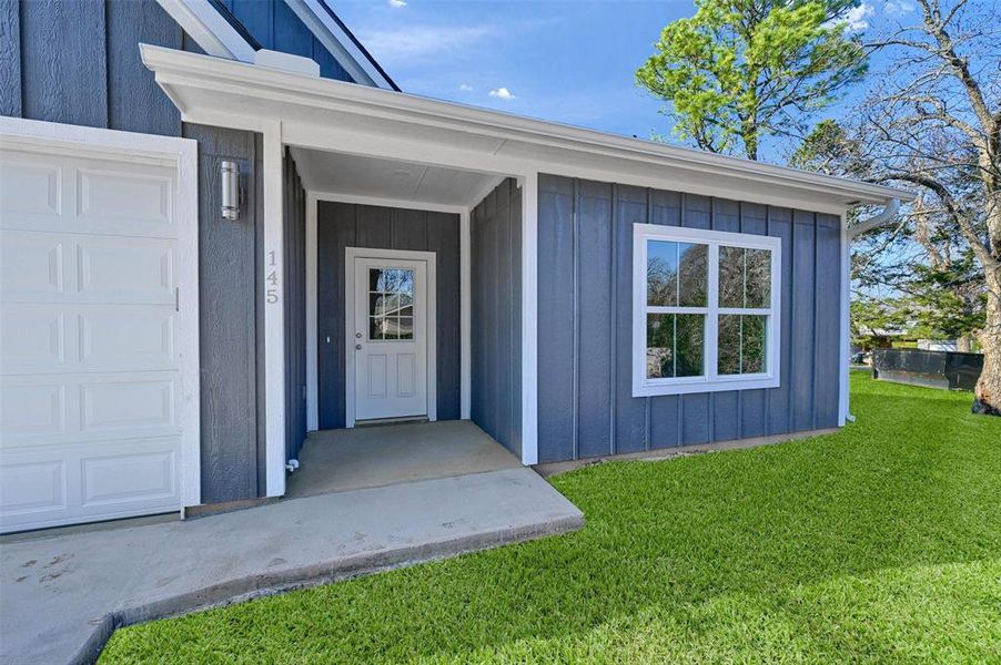 Doorway to property with a lawn