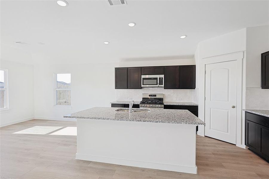 Kitchen featuring a center island with sink, stainless steel appliances, and sink