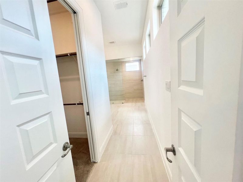 Hall featuring baseboards and light tile patterned floors Hall featuring baseboards and light tile patterned floors