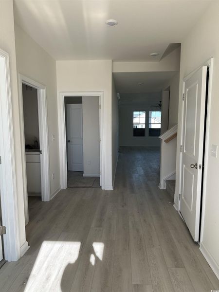 Hallway featuring light wood-style flooring and baseboards