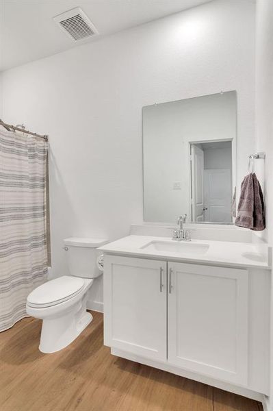 Full en-suite bath #2 with light wood-type flooring, vanity, and a shower with shower curtain