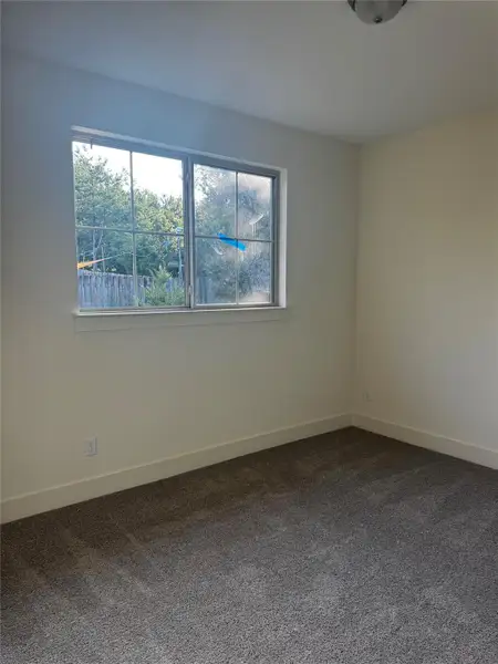 Unfurnished room with dark carpet and baseboards Unfurnished room with dark carpet and baseboards