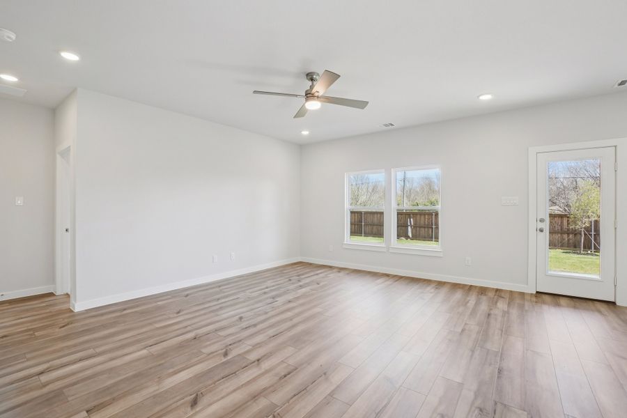 A room with a wood floor and a ceiling fan.