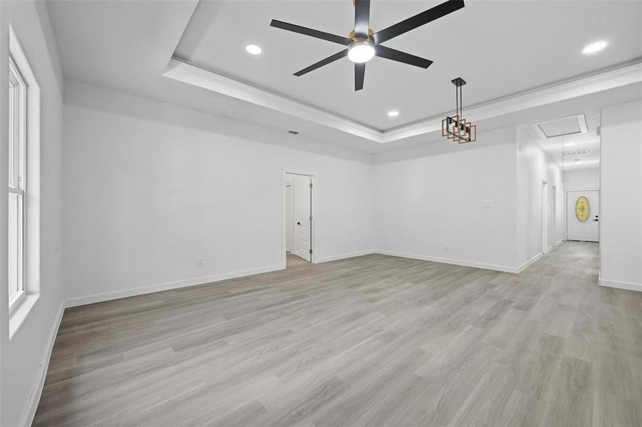 Spare room featuring attic access, a tray ceiling, light wood finished floors, recessed lighting, and ceiling fan Spare room featuring attic access, a tray ceiling, light wood finished floors, recessed lighting, and ceiling fan