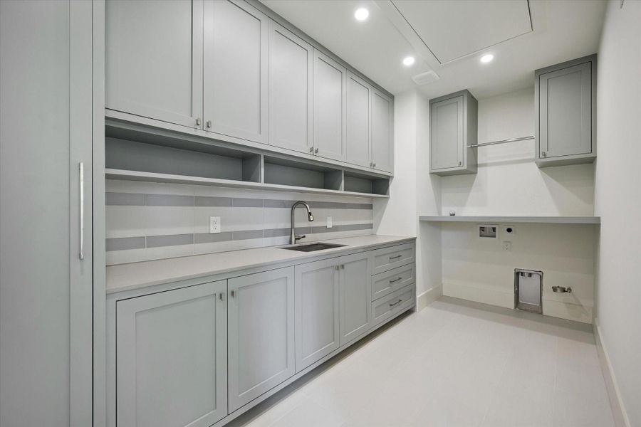 Spacious laundry room with custom cabinetry and ample storage. Spacious laundry room with custom cabinetry and ample storage.