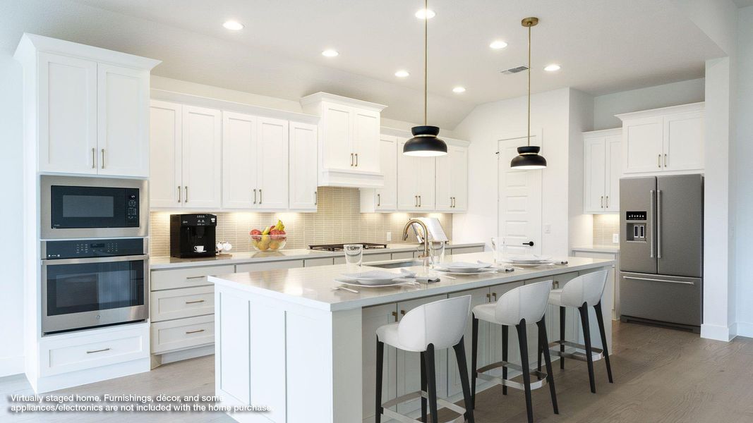 Kitchen featuring backsplash, a breakfast bar area, appliances with stainless steel finishes, white cabinetry, and a kitchen island with sink Kitchen featuring backsplash, a breakfast bar area, appliances with stainless steel finishes, white cabinetry, and a kitchen island with sink