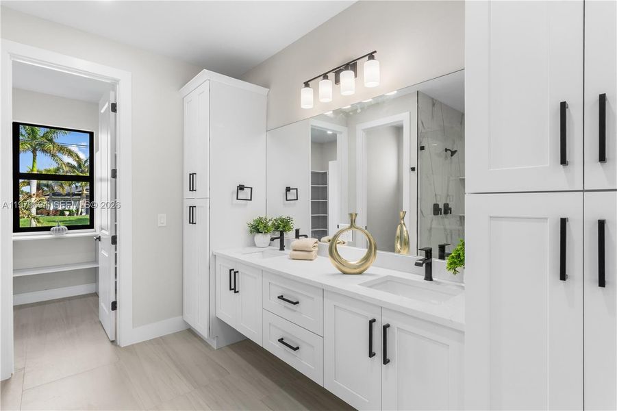 Dual-sink vanity w/ quartz countertops, sleek white cabinetry & contemporary lighting complements the spa-like design. Dual-sink vanity w/ quartz countertops, sleek white cabinetry & contemporary lighting complements the spa-like design.
