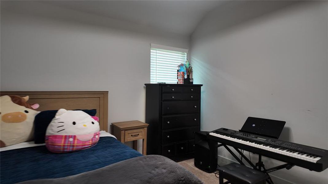 The property features a room with light-colored walls and a window with blinds, providing natural light