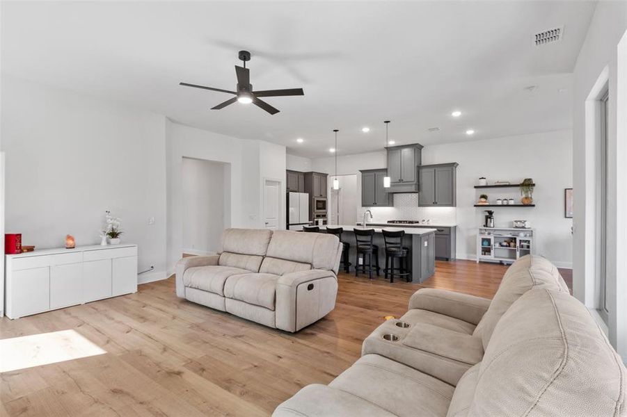 Living area featuring light wood-style flooring, recessed lighting, and ceiling fan