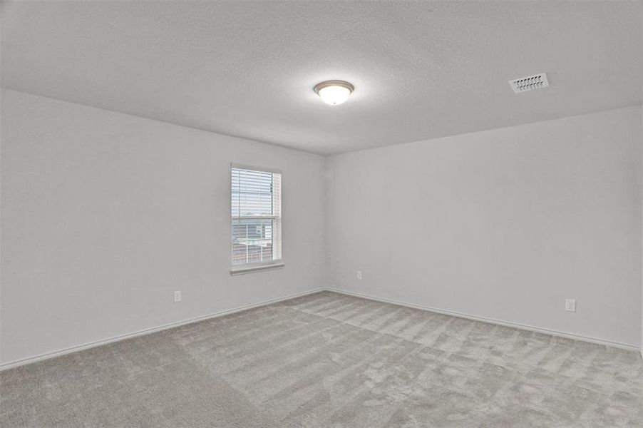 Carpeted room with a flush-mount ceiling light fixture, white walls, baseboards, and a window featuring blinds