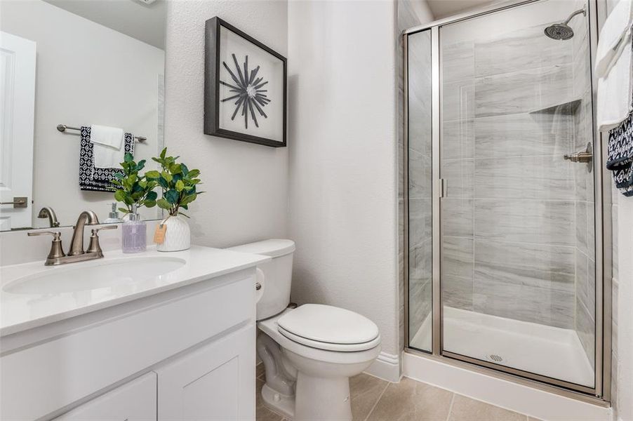 Full bathroom with a stall shower, vanity, and light tile patterned floors
