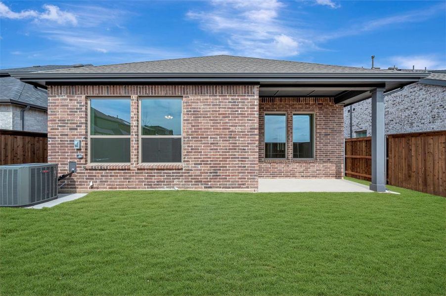 Rear view of house with a patio area, a shingled roof, and brick siding Rear view of house with a patio area, a shingled roof, and brick siding