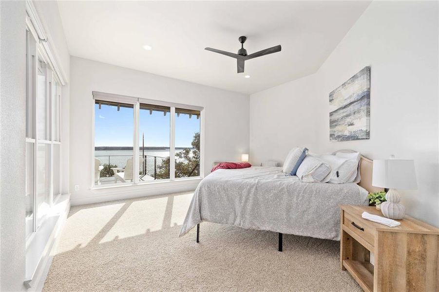 Carpeted bedroom featuring ceiling fan, recessed lighting, and a water view