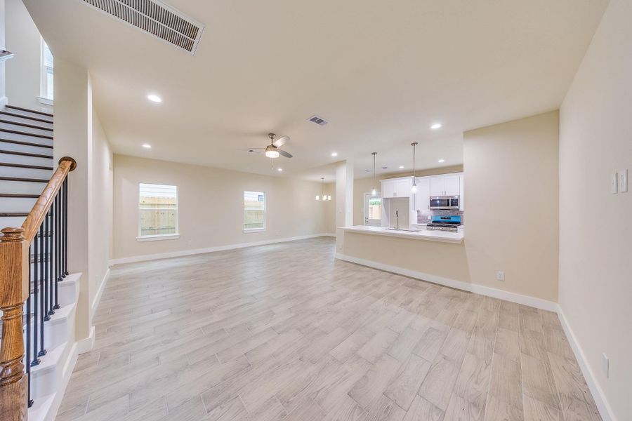 Ceiling fans in the living room and warm woodlike flooring, creating a comfortable and inviting space. Ceiling fans in the living room and warm woodlike flooring, creating a comfortable and inviting space.